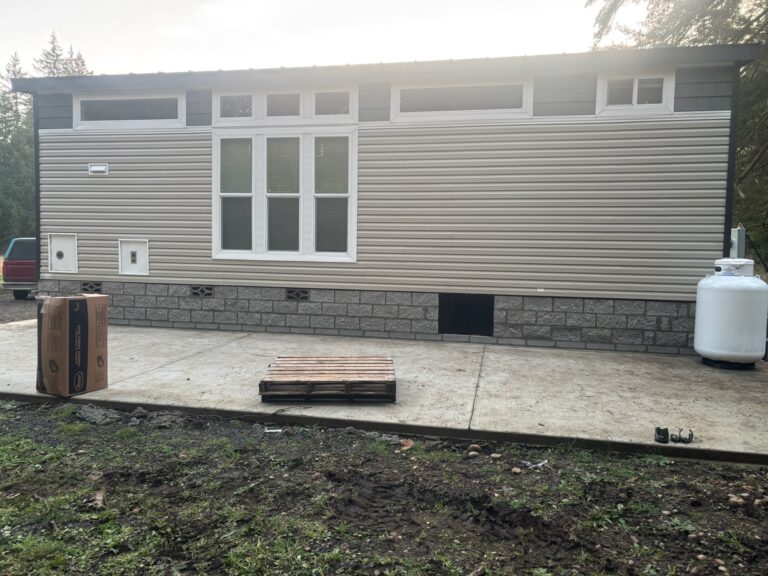 Manufactured home with new siding and a concrete patio