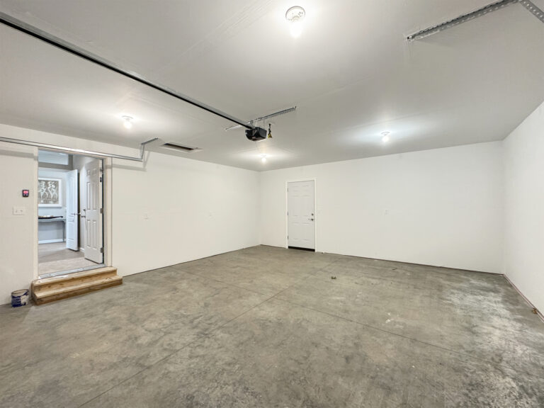Finished garage interior with a door leading into the manufactured home