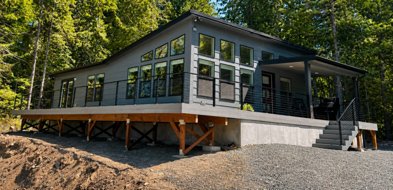 Manufactured home with a large wraparound composite deck, cable railing and stairs
